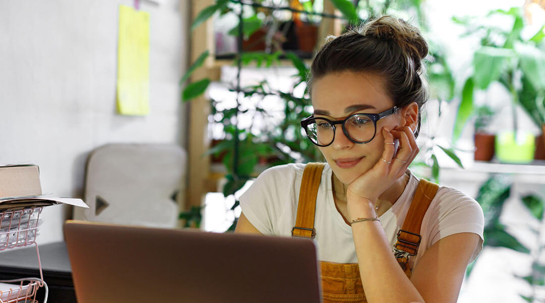 Female business owner working on her laptop from home.