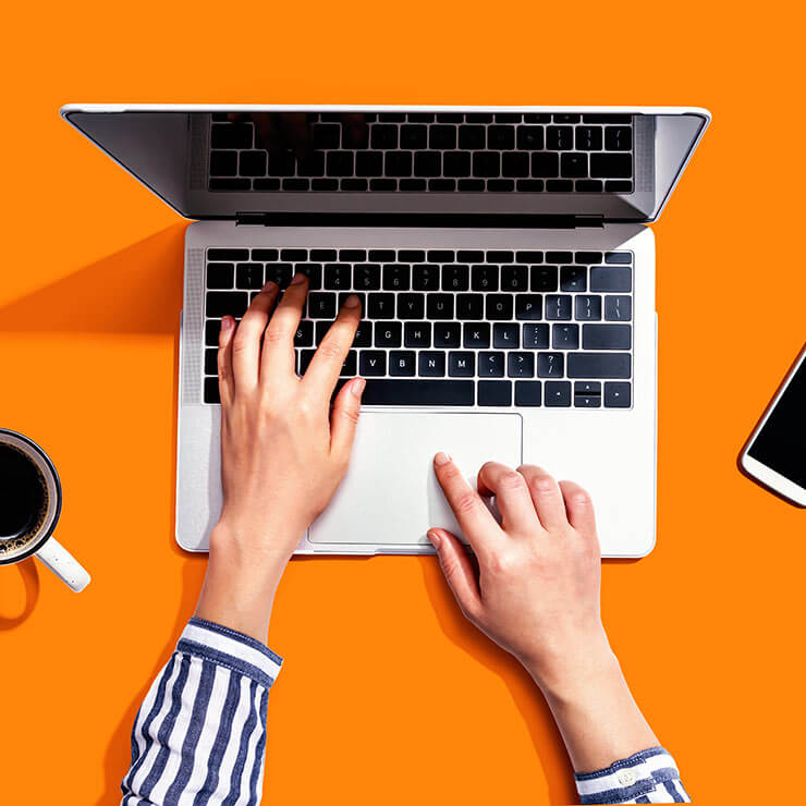 Woman's hands typing on laptop as she works as a freelance copywriter,